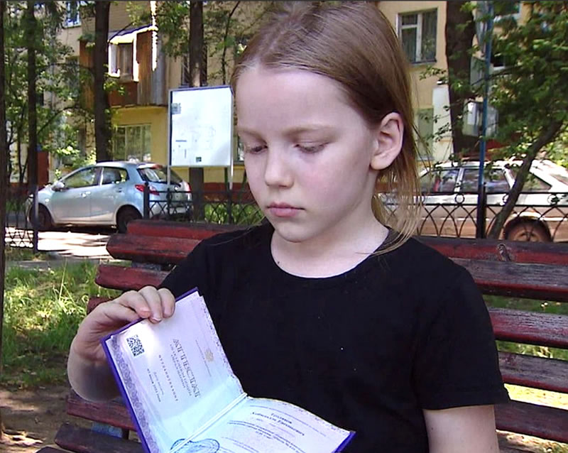 Восьмилетний Хеймдалль Тепляков показывает полученный аттестат о среднем образовании